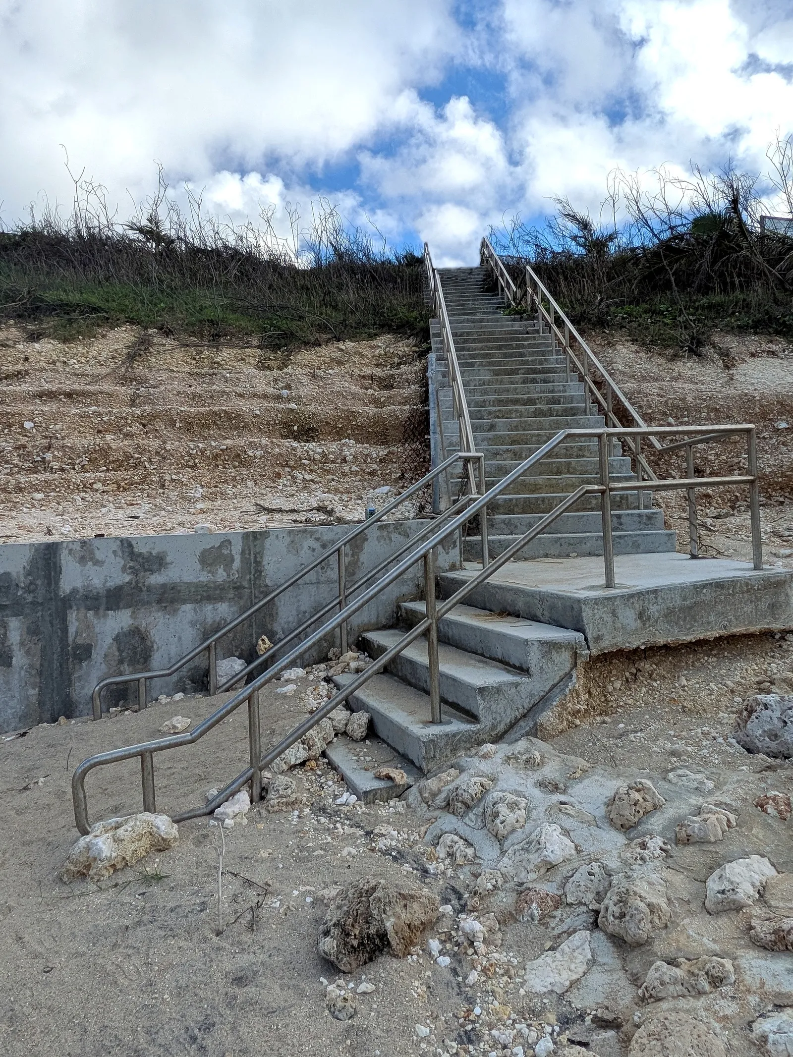 The new concrete stairway with steel handrails leading from the road down to the shore at Unai Fanhang