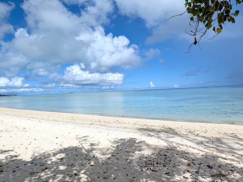 The beach at Paupau curving north toward a distant rocky point