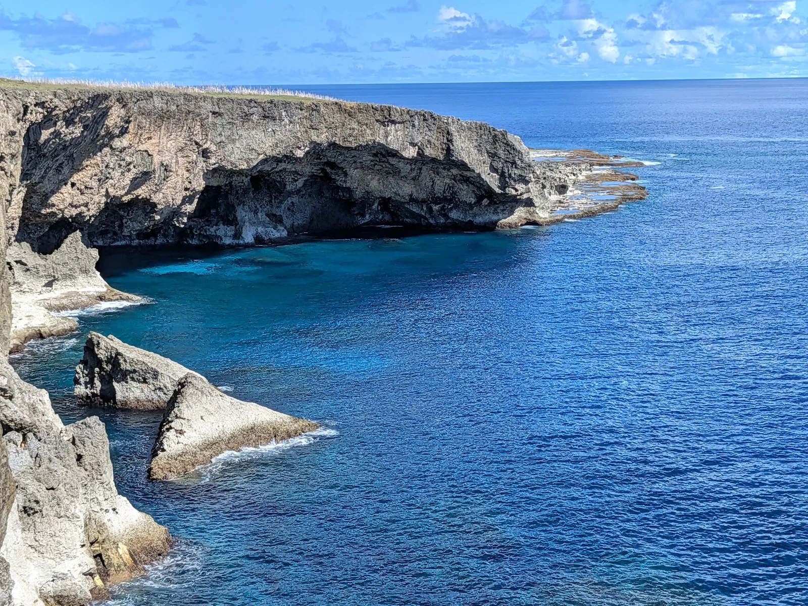 Undercut limestone cliffs and turquoise shallows below Banzai Cliff at Marpi Point, northern Saipan