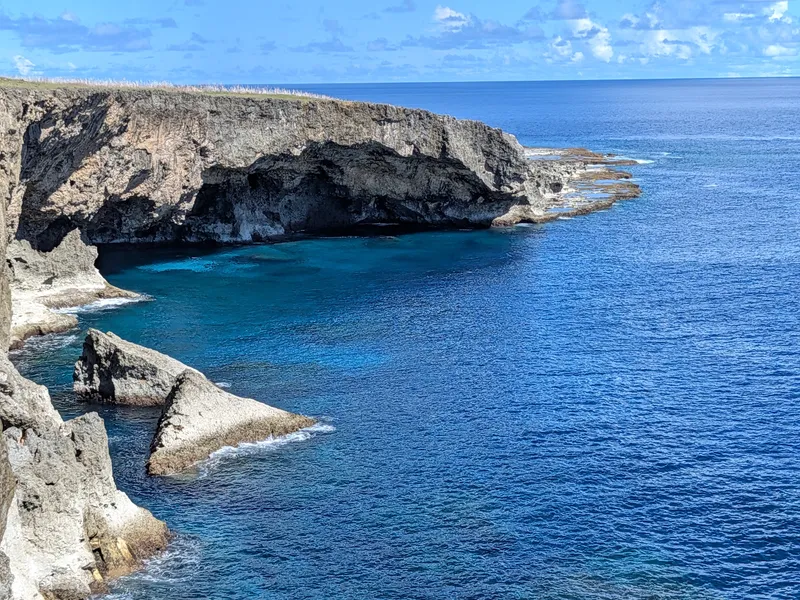 Undercut limestone cliffs and turquoise shallows below Banzai Cliff at Marpi Point, northern Saipan
