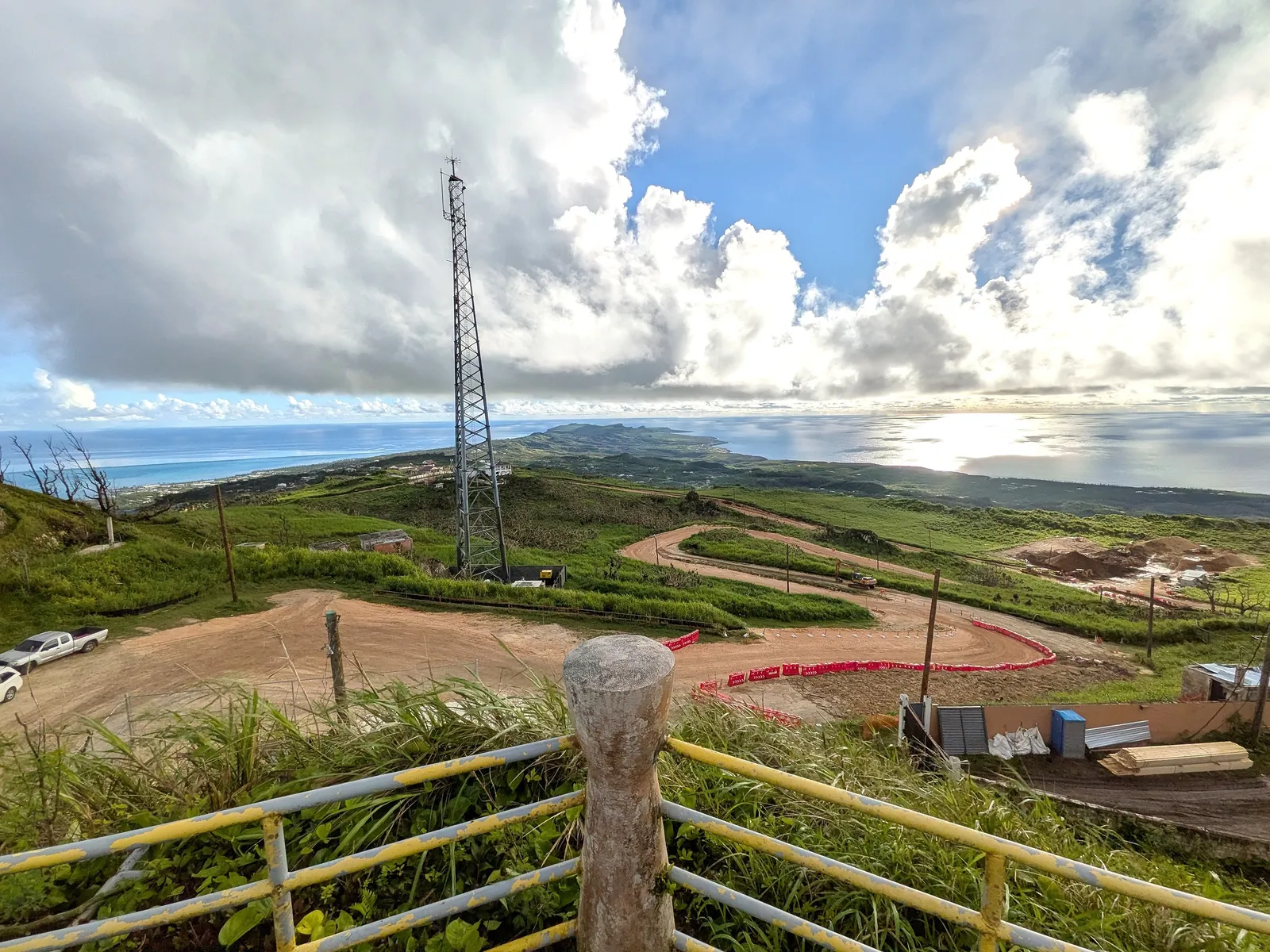 The modern communications tower at the Mount Tapochau summit, with coastline visible on both sides below