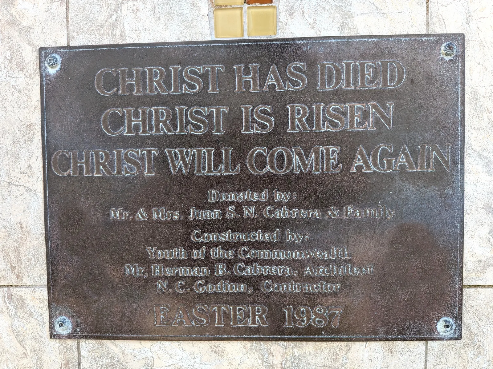 The bronze dedication plaque at the base of the summit statue, reading Christ Has Died, Christ Is Risen, Christ Will Come Again, dated Easter 1987