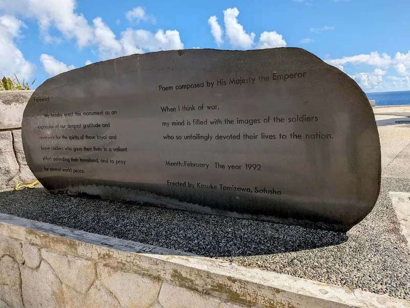 A polished stone monument at Banzai Cliff carrying an English translation of a poem composed by the Emperor, dated February 1992