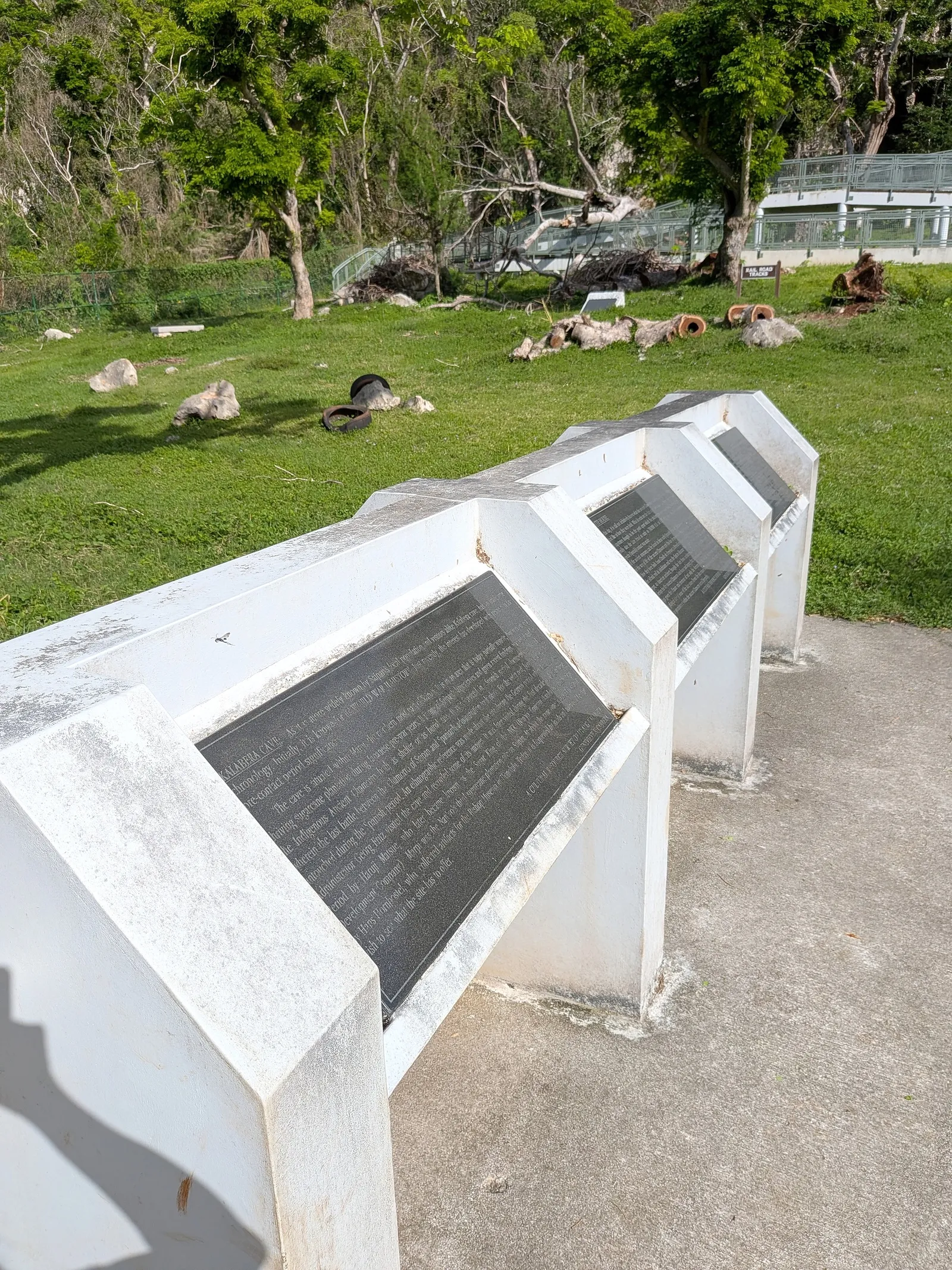 The row of interpretive panels on the lawn at Kalabera Cave, set into angled white concrete plinths