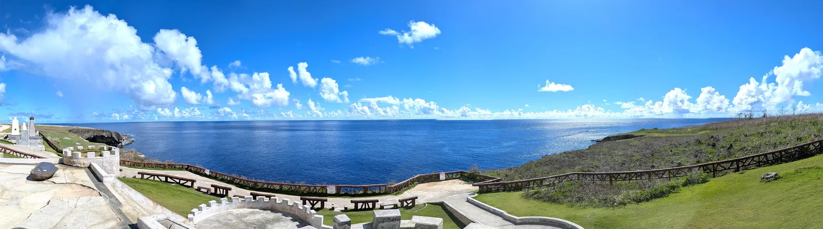 Panorama from Banzai Cliff across Marpi Point, showing the clifftop memorial park, the railed path, and the open Pacific