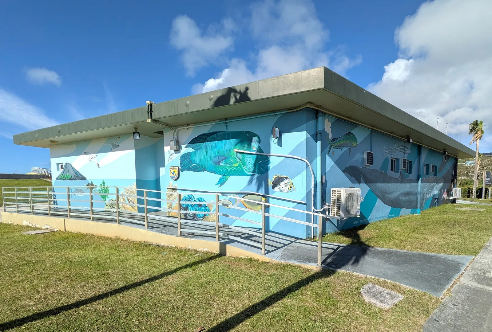 A building at American Memorial Park painted with a large ocean-life mural, including a whale and reef fish