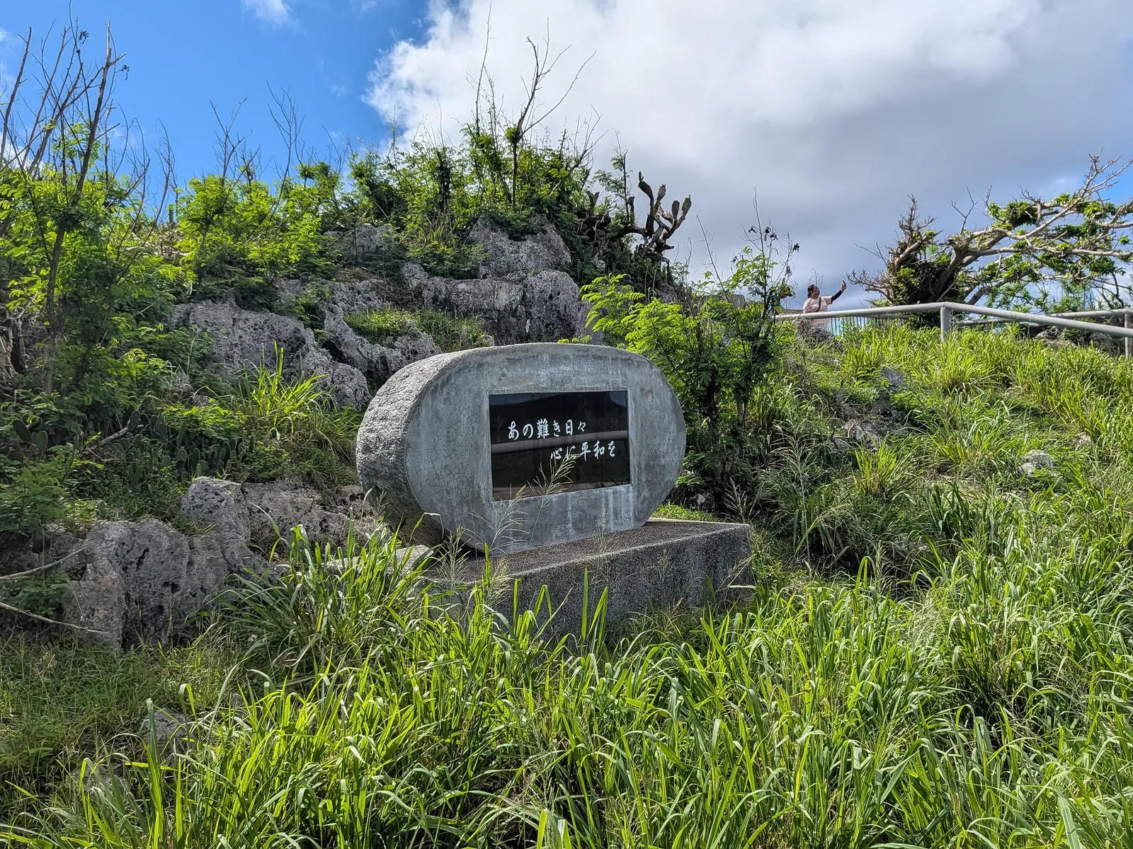 A separate inscribed peace monument stone at Suicide Cliff, set among the limestone rocks