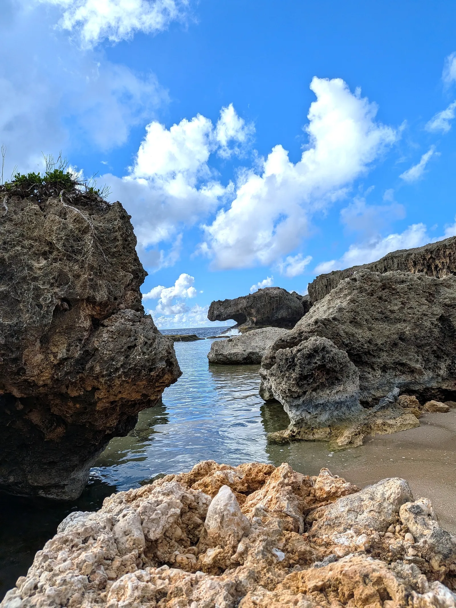 The channel at Unai Fanhang framed between two weathered limestone boulders