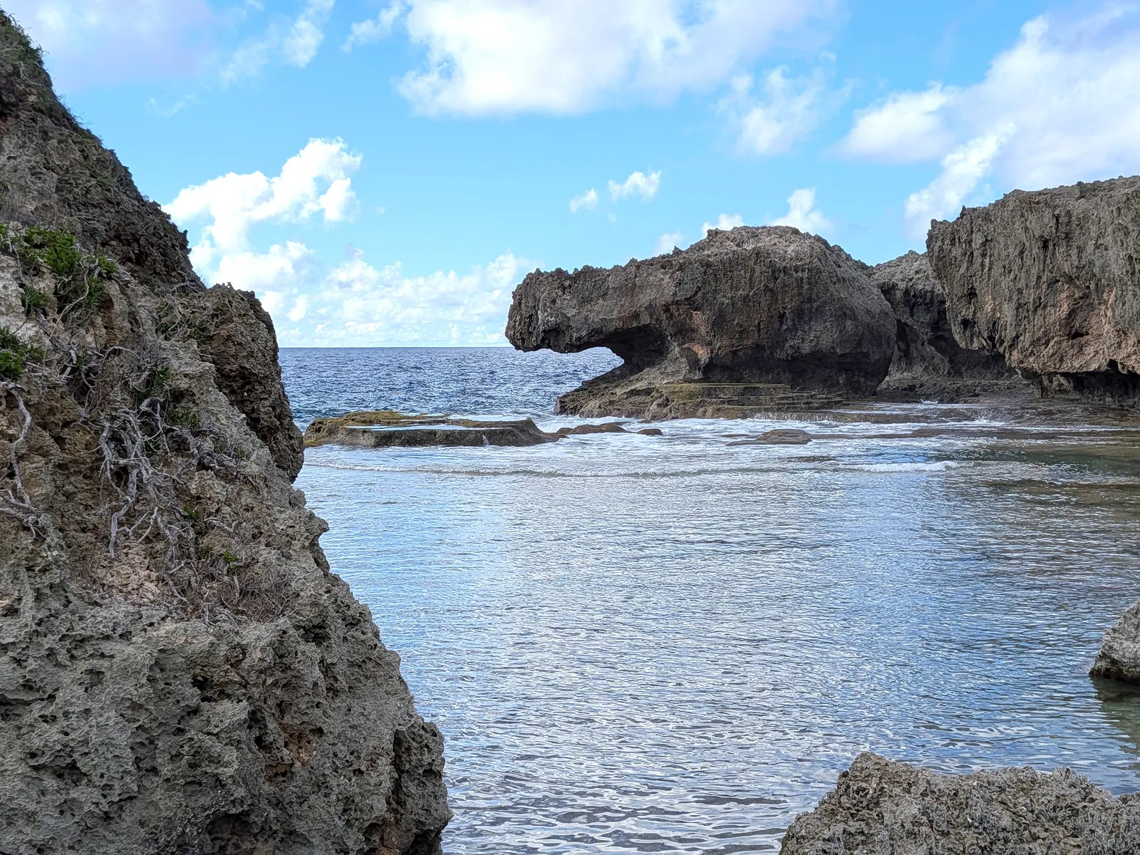 Undercut sea caves at the base of the limestone headland at Unai Fanhang, exposed at low tide