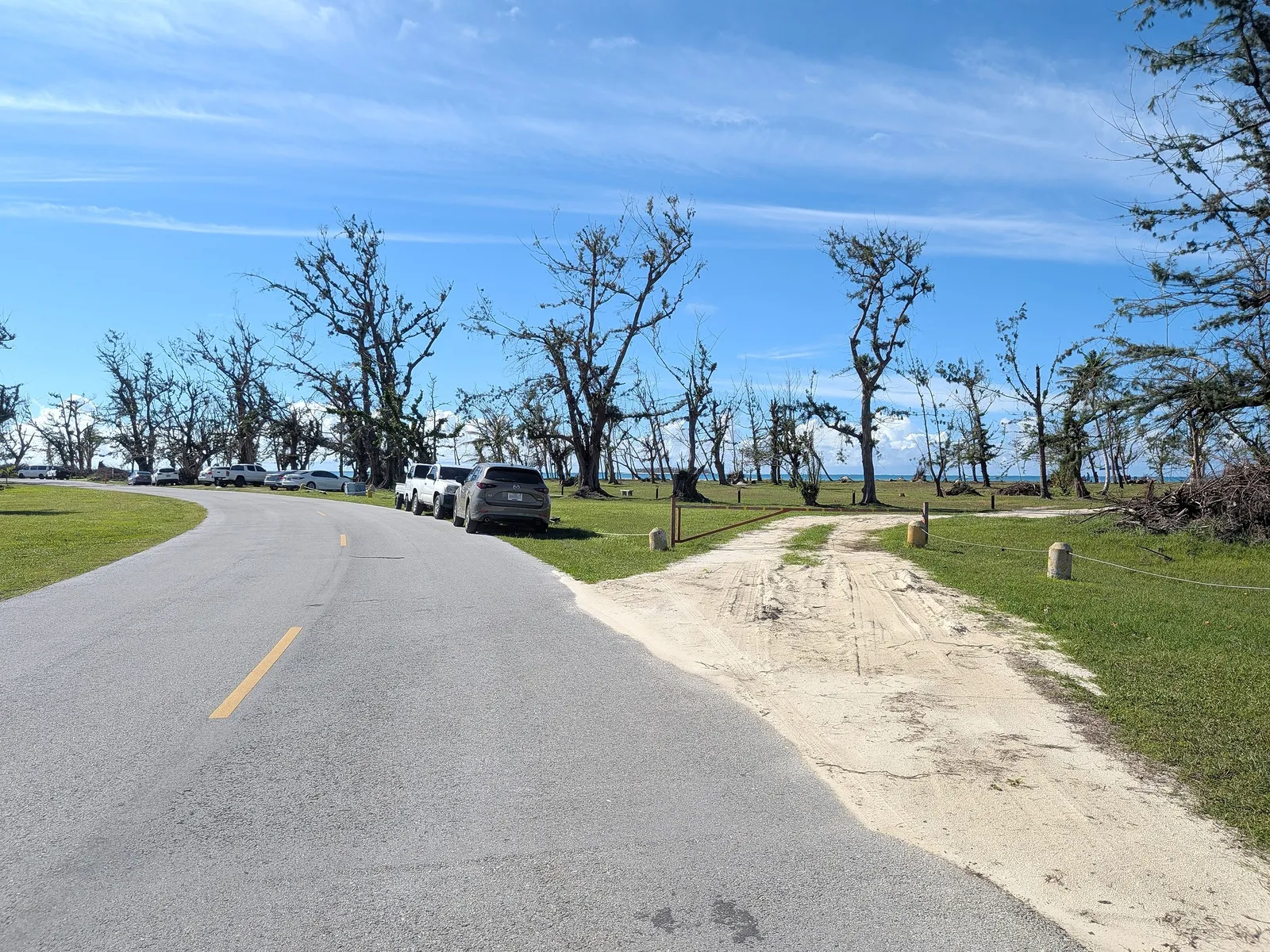 Beach Road next to Micro Beach with street parking on both sides and a sandy access path down to the sand