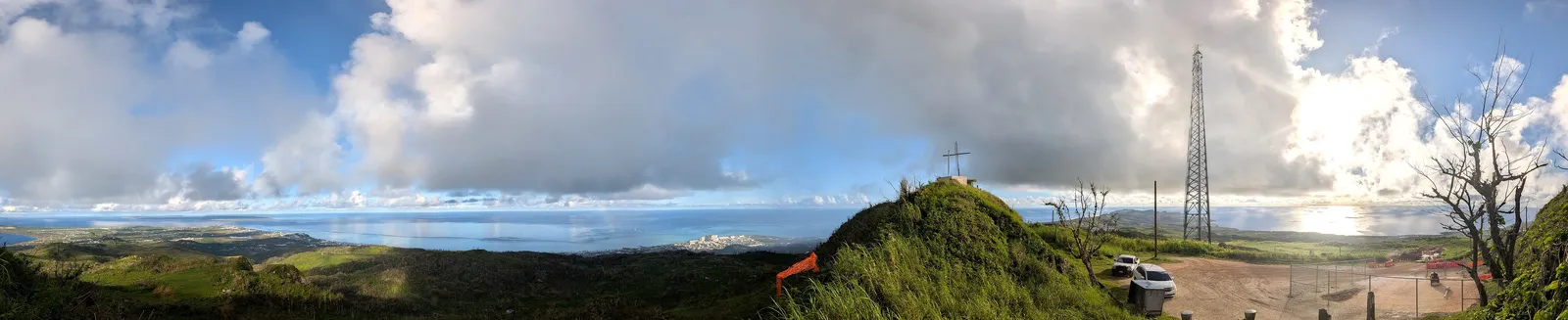 A 360-degree panorama from the summit of Mount Tapochau, showing the communications tower, the wooden cross, and coastline on both sides of the island