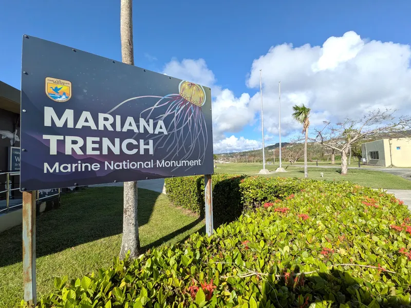 The American Memorial Park Visitor Center entrance, with its distinctive angled roof and a mosaic map of the Mariana Islands in the plaza