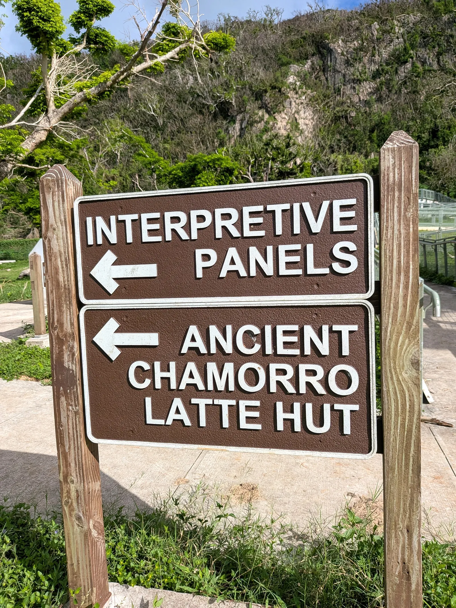 Wayfinding signs at Kalabera Cave pointing toward the interpretive panels and the ancient CHamoru latte hut